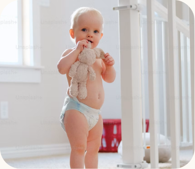Baby standing beside a cot